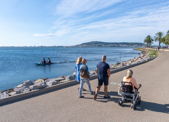 Groupe de personnes qui marche au bord de l'étang de Thau à Balaruc