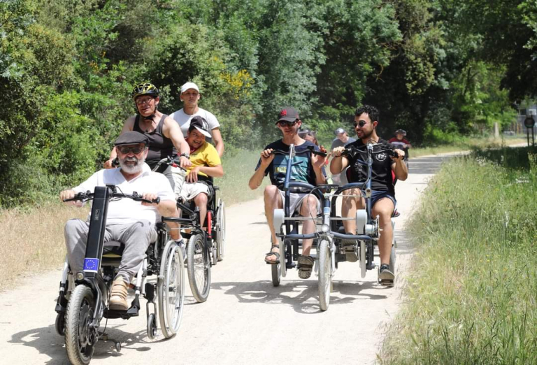 Un groupe de personnes en situation de handicap moteur se promènent sur la passa pais en vélo