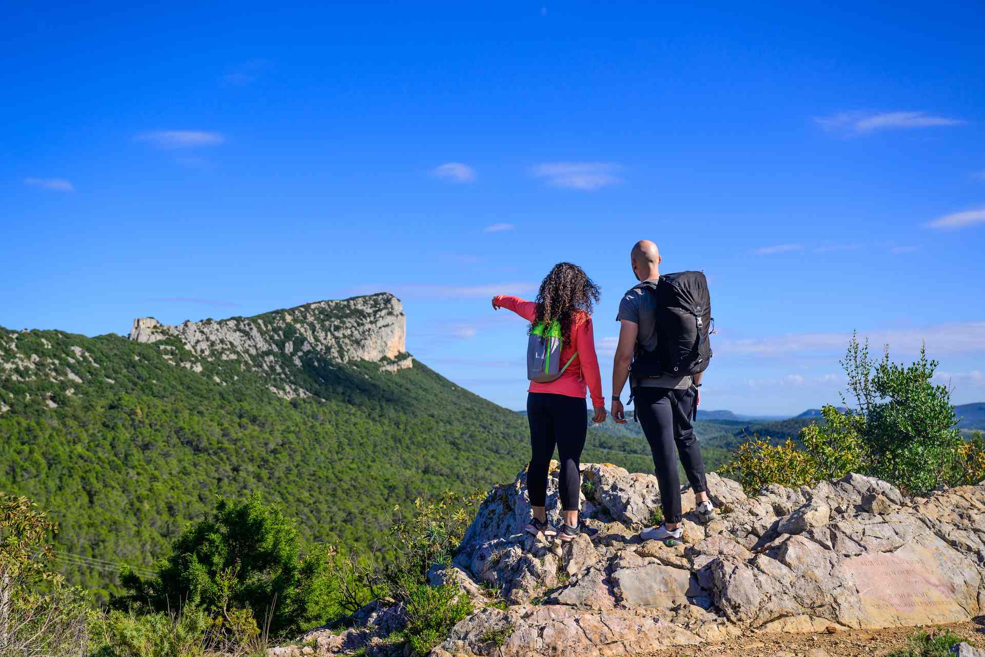 Couple en rando devant le Pic St Loup et l'Hortus